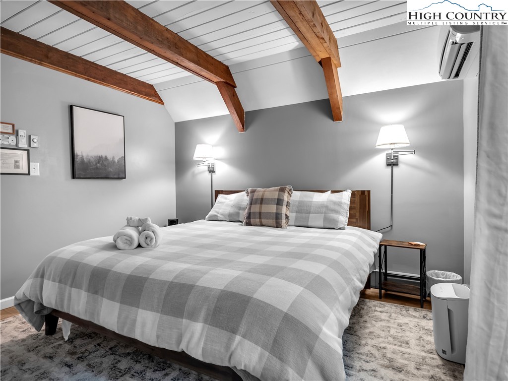 404 Charter Hills Road Beech Mountain, NC 28604 - Photo 14 of 36 a bedroom with a bed and a lamp