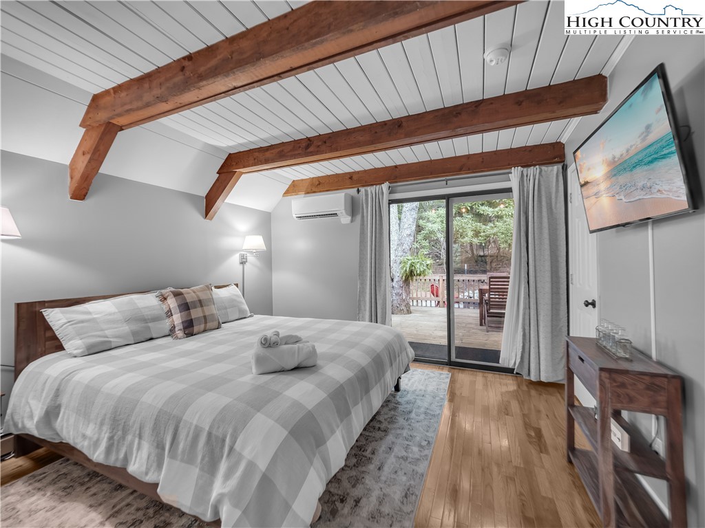 404 Charter Hills Road Beech Mountain, NC 28604 - Photo 15 of 36 a bedroom with a bed and a large window