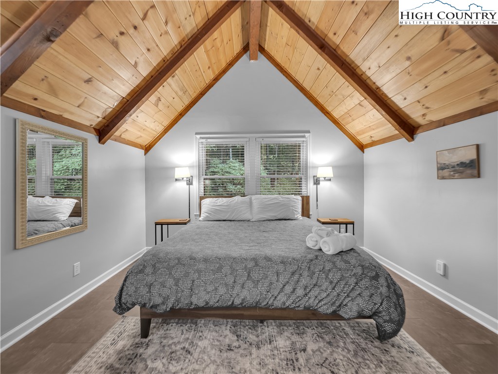 404 Charter Hills Road Beech Mountain, NC 28604 - Photo 22 of 36 a bedroom with a large bed and wooden floor