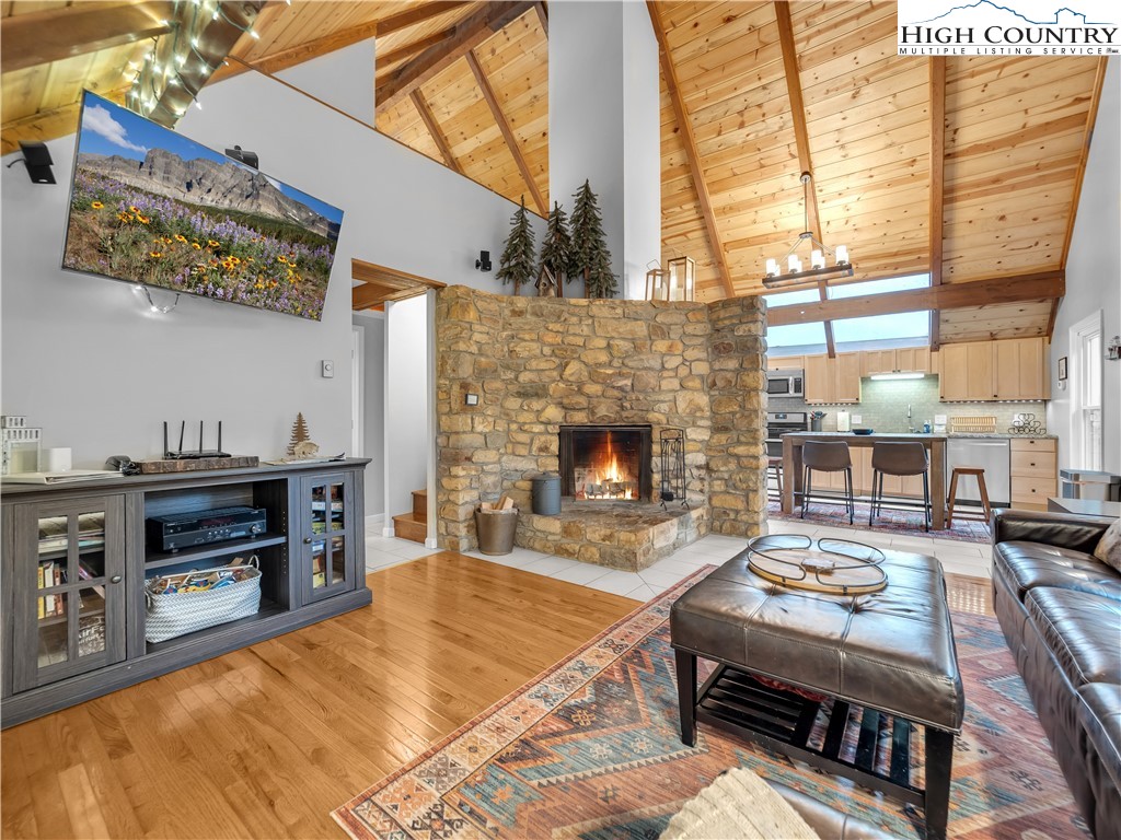 404 Charter Hills Road Beech Mountain, NC 28604 - Photo 5 of 36 a living room with furniture a fireplace and a large window