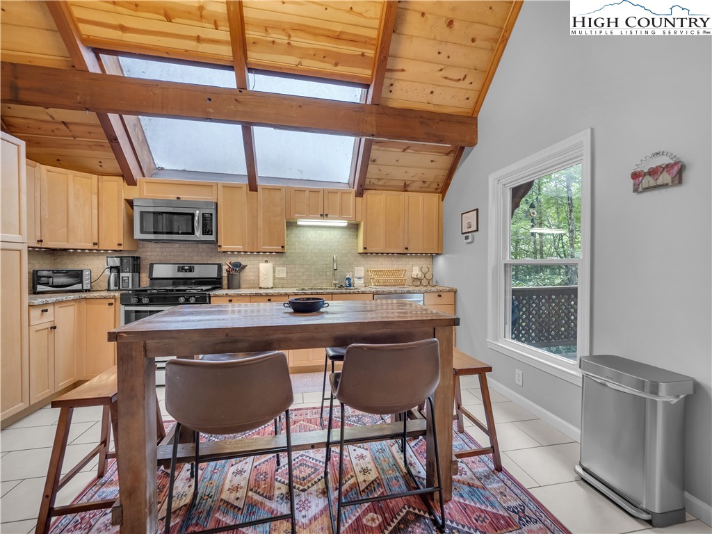 404 Charter Hills Road Beech Mountain, NC 28604 - Photo 10 of 36 a kitchen with stainless steel appliances granite countertop a stove a sink dishwasher and cabinets with wooden floor