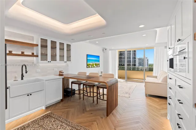 a large white kitchen with lots of counter top space and dining table