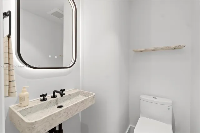 a bathroom with a sink a toilet and a mirror