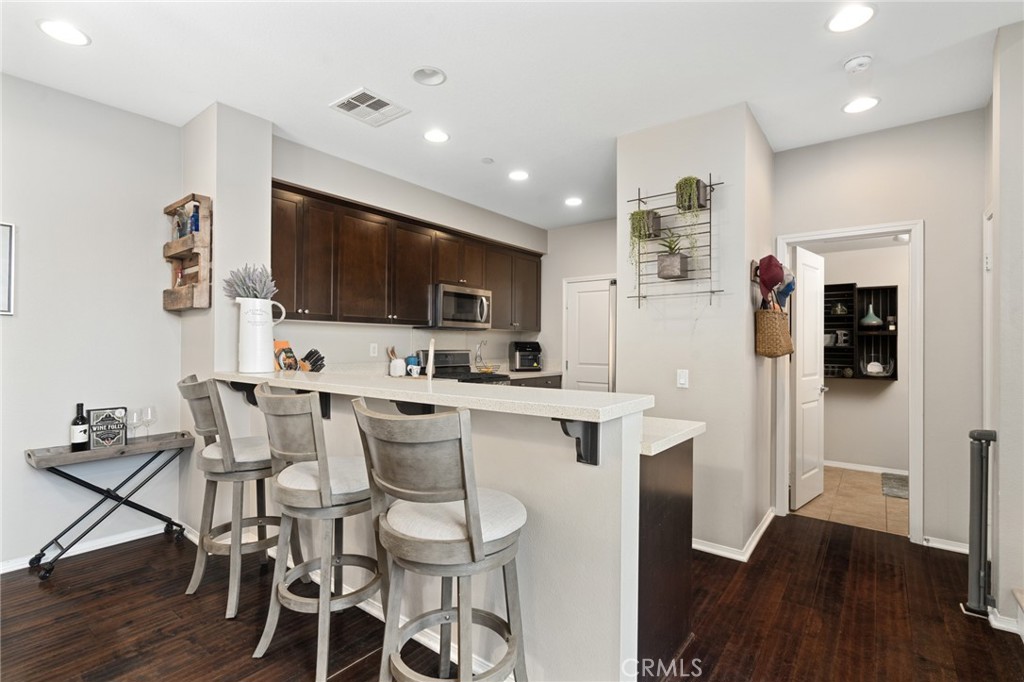 a living room with stainless steel appliances kitchen island granite countertop a sink and cabinets