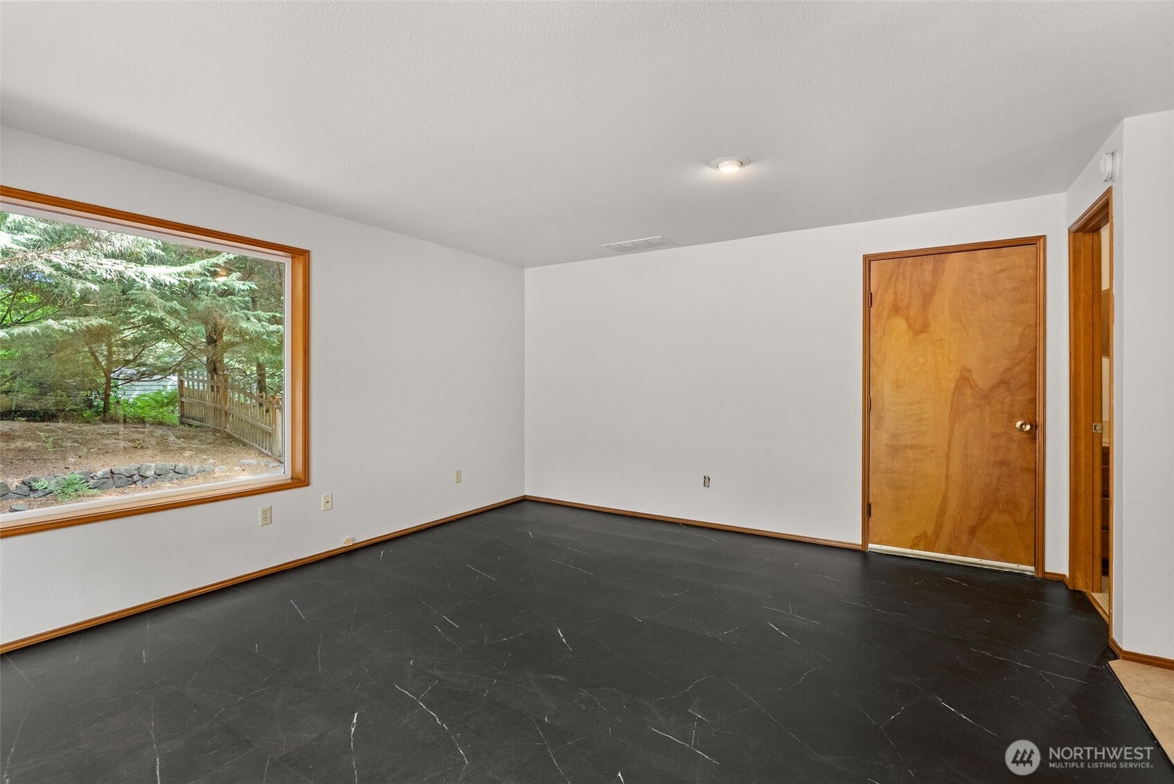 6333 Boardman Road Northwest Olympia, WA 98502 - Photo 15 of 38 a view of an empty room with wooden floor and a window
