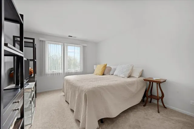 a bedroom with a bed flat screen tv and a large window