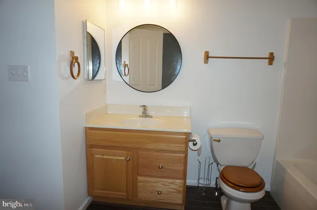 a bathroom with a toilet a sink and a mirror