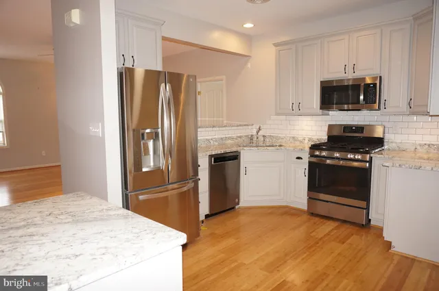 a kitchen with stainless steel appliances granite countertop a refrigerator stove and microwave