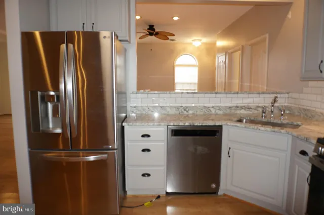 a kitchen with stainless steel appliances granite countertop a refrigerator and a sink