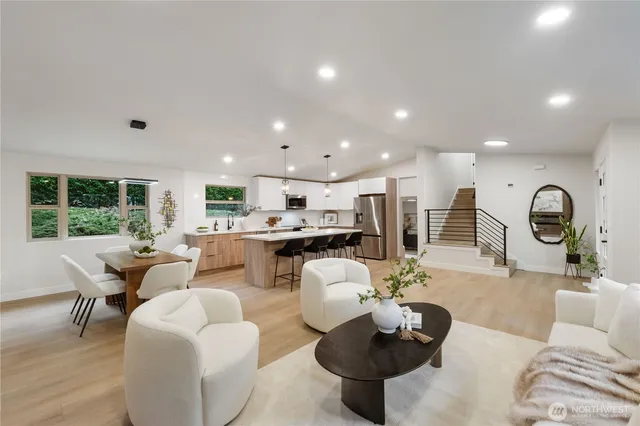 a living room with furniture a large window and kitchen view