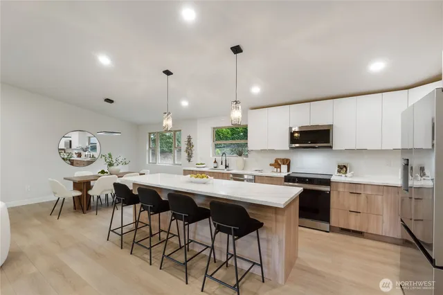 a kitchen with appliances a table and chairs in it