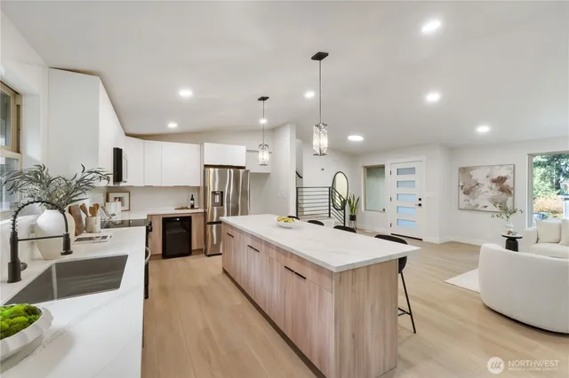 a large kitchen with kitchen island a large counter top space a sink stainless steel appliances and cabinets