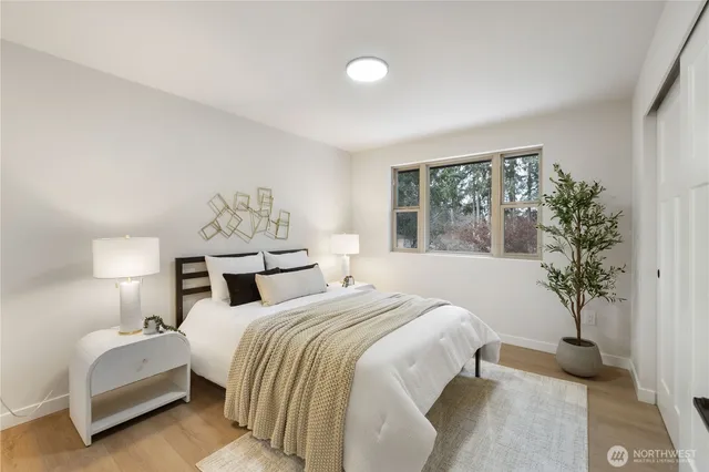 a bedroom with a large bed and a potted plant