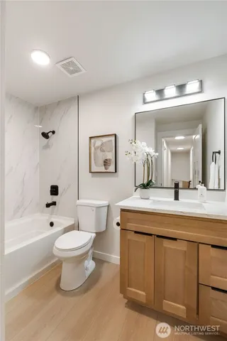 a bathroom with a sink toilet a mirror and shower