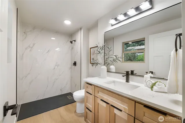 a bathroom with a double vanity sink a toilet and a mirror