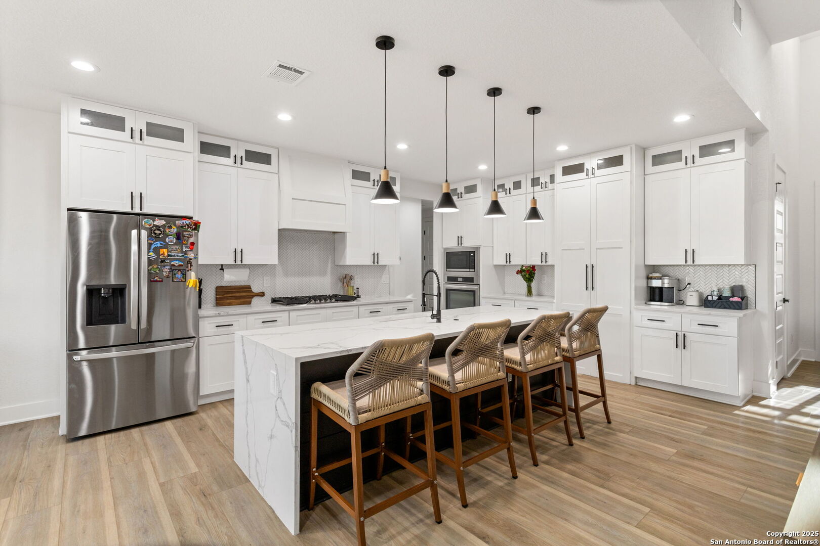 187 Stone Loop Castroville, TX 78009 - Photo 11 of 30 a kitchen with stainless steel appliances kitchen island granite countertop a refrigerator and a stove top oven