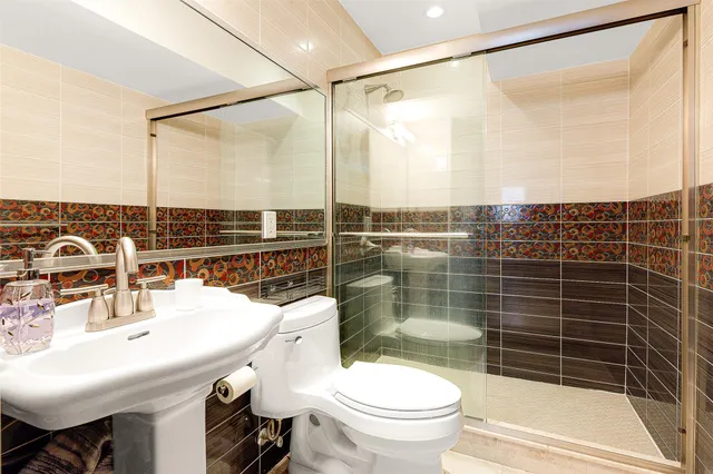 a bathroom with a sink mirror toilet and shower