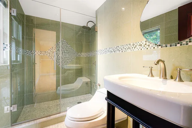 a room with pool table a chandelier and windows