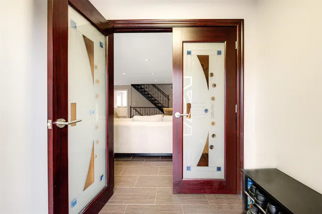 a view of a hallway with wooden floor and a bathroom