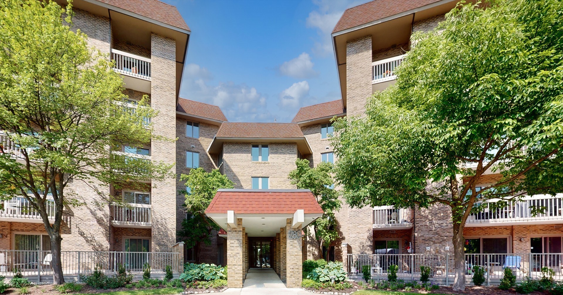1280 Rudolph Drive, Unit 5E Northbrook, IL 60062 - Photo 1 of 33 a front view of a multi story building with a yard
