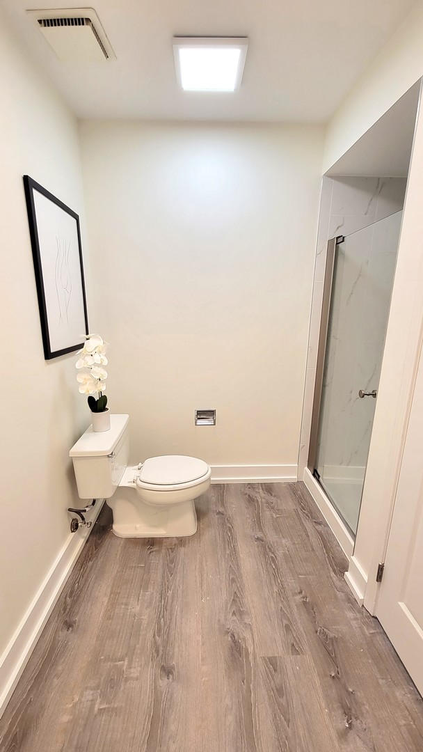 1280 Rudolph Drive, Unit 5E Northbrook, IL 60062 - Photo 14 of 33 a bathroom with a toilet a sink and mirror