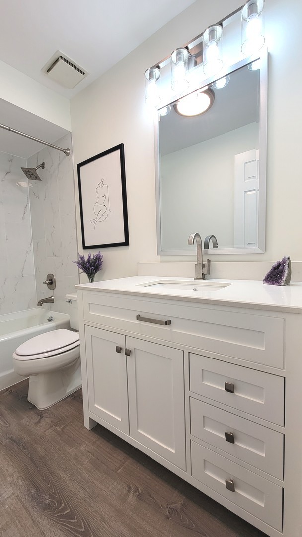 1280 Rudolph Drive, Unit 5E Northbrook, IL 60062 - Photo 17 of 33 a bathroom with a toilet a sink and mirror