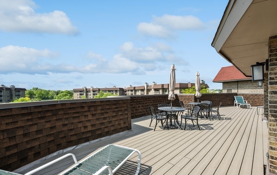 1280 Rudolph Drive, Unit 5E Northbrook, IL 60062 - Photo 26 of 33 a view of a roof deck with table and chairs under an umbrella