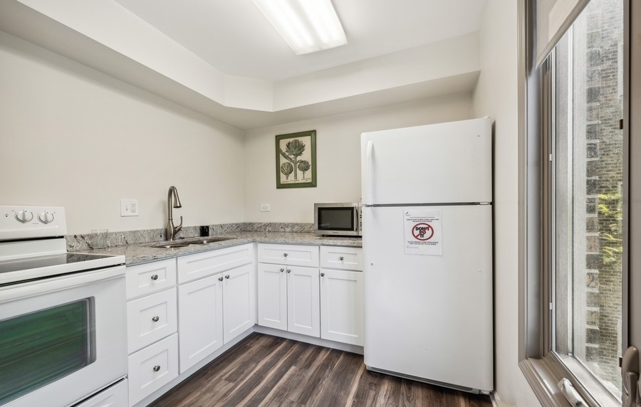 1280 Rudolph Drive, Unit 5E Northbrook, IL 60062 - Photo 29 of 33 a kitchen with white cabinets and white appliances