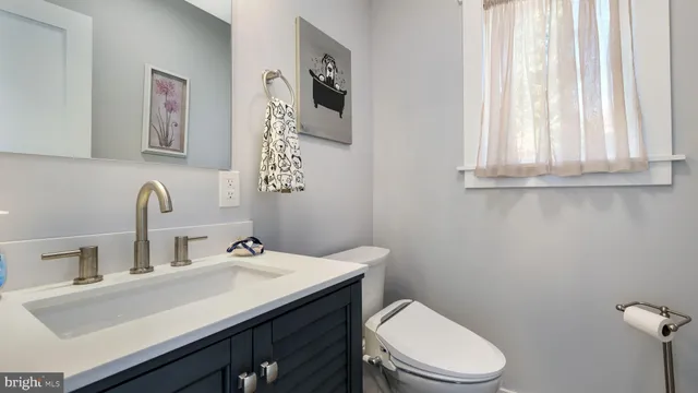 a bathroom with a toilet a sink and mirror