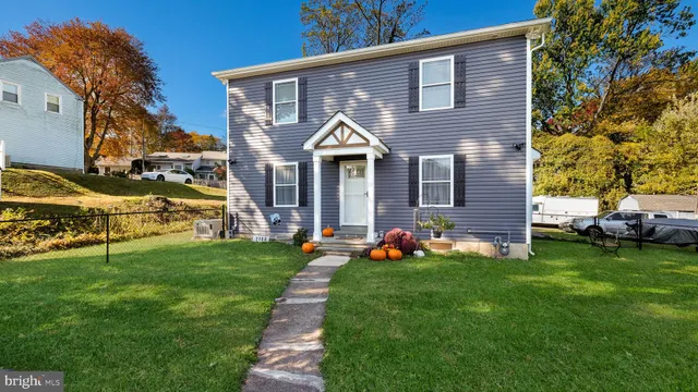 a front view of a house with a yard and trees