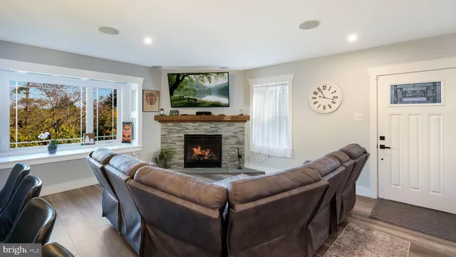 a living room with furniture a flat screen tv and a fireplace