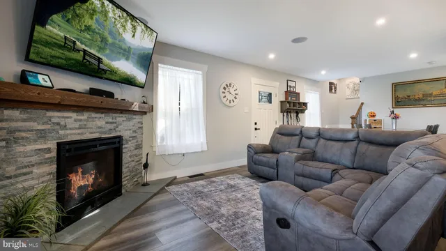 a living room with furniture a flat screen tv and a fireplace