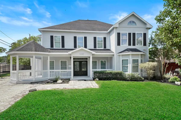 a front view of a house with a yard and trees