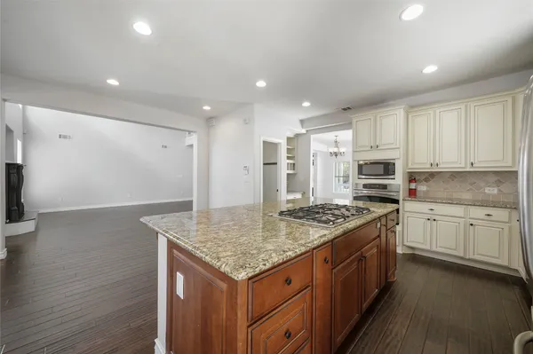 a kitchen with stainless steel appliances granite countertop a stove a sink and a refrigerator