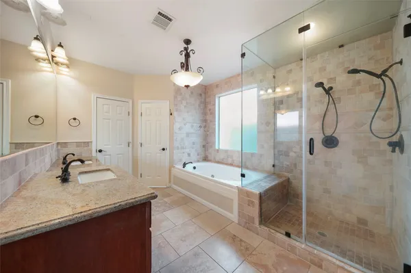a bathroom with a tub a sink shower and mirror