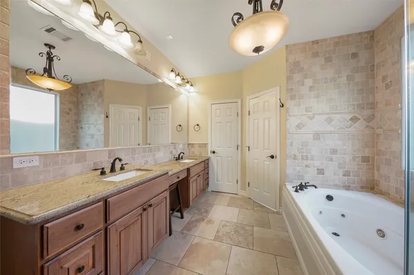 a bathroom with a tub sink shower and mirror