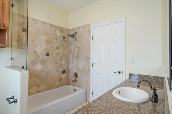 a bathroom with a sink a mirror a bathtub and shower