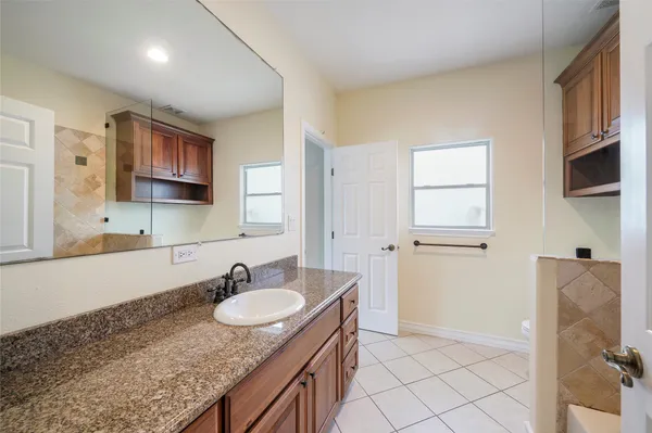 a bathroom with a granite countertop sink and a mirror