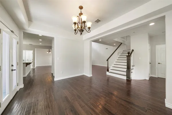 a view of a hallway with wooden floor and staircase