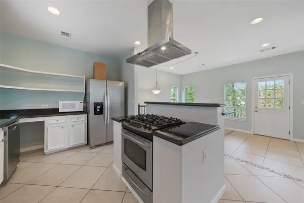 a kitchen with granite countertop stainless steel appliances a stove a sink and a refrigerator