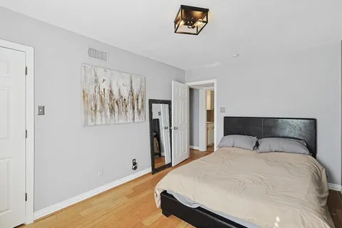 a bedroom with a bed and a painting on the wall