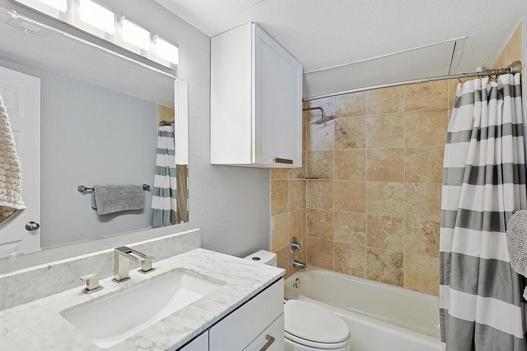 2722 Knight Street, Unit 232A Dallas, TX 75219 - Photo 17 of 24 a bathroom with a sink shower bathtub and a mirror