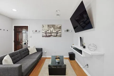 a living room with furniture and wooden floor
