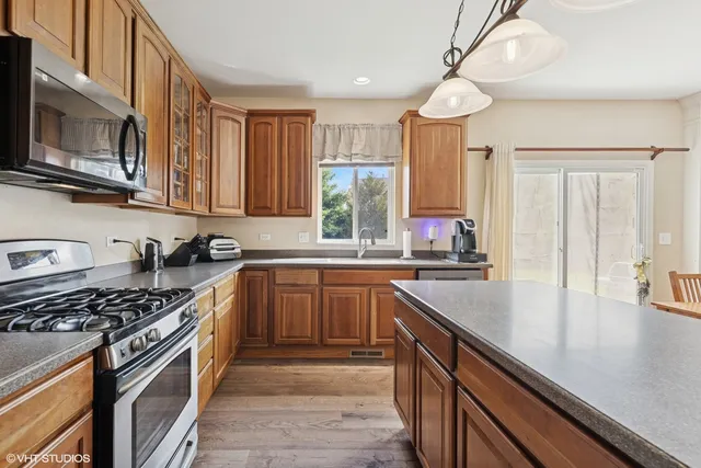a kitchen with stainless steel appliances a sink a stove and cabinets