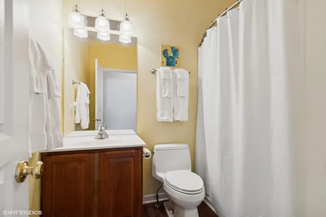 a bathroom with a sink a toilet and shower curtain