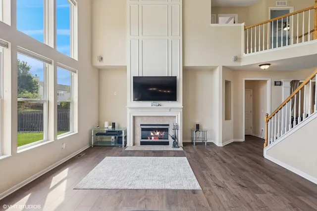 a living room with furniture a fireplace and a large window