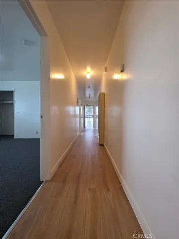 a view of a hallway with wooden floor