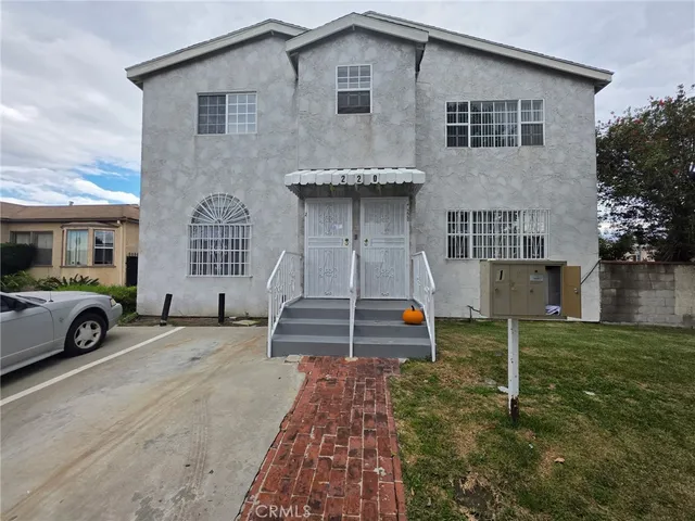 a view of a house with a yard and parking space