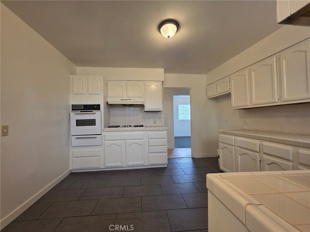 220 South Pannes Avenue, Unit 1 Compton, CA 90221 - Photo 5 of 15 a kitchen with stainless steel appliances a stove and white cabinets