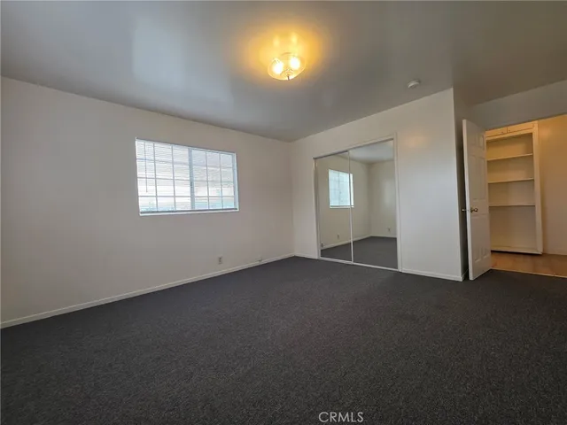 an empty room with windows and closet